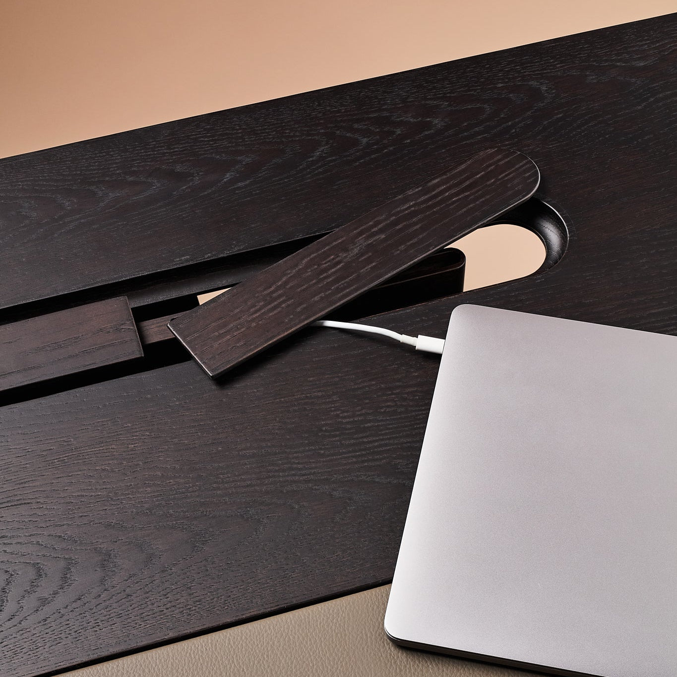 Laptop on a wooden desk with a beige background