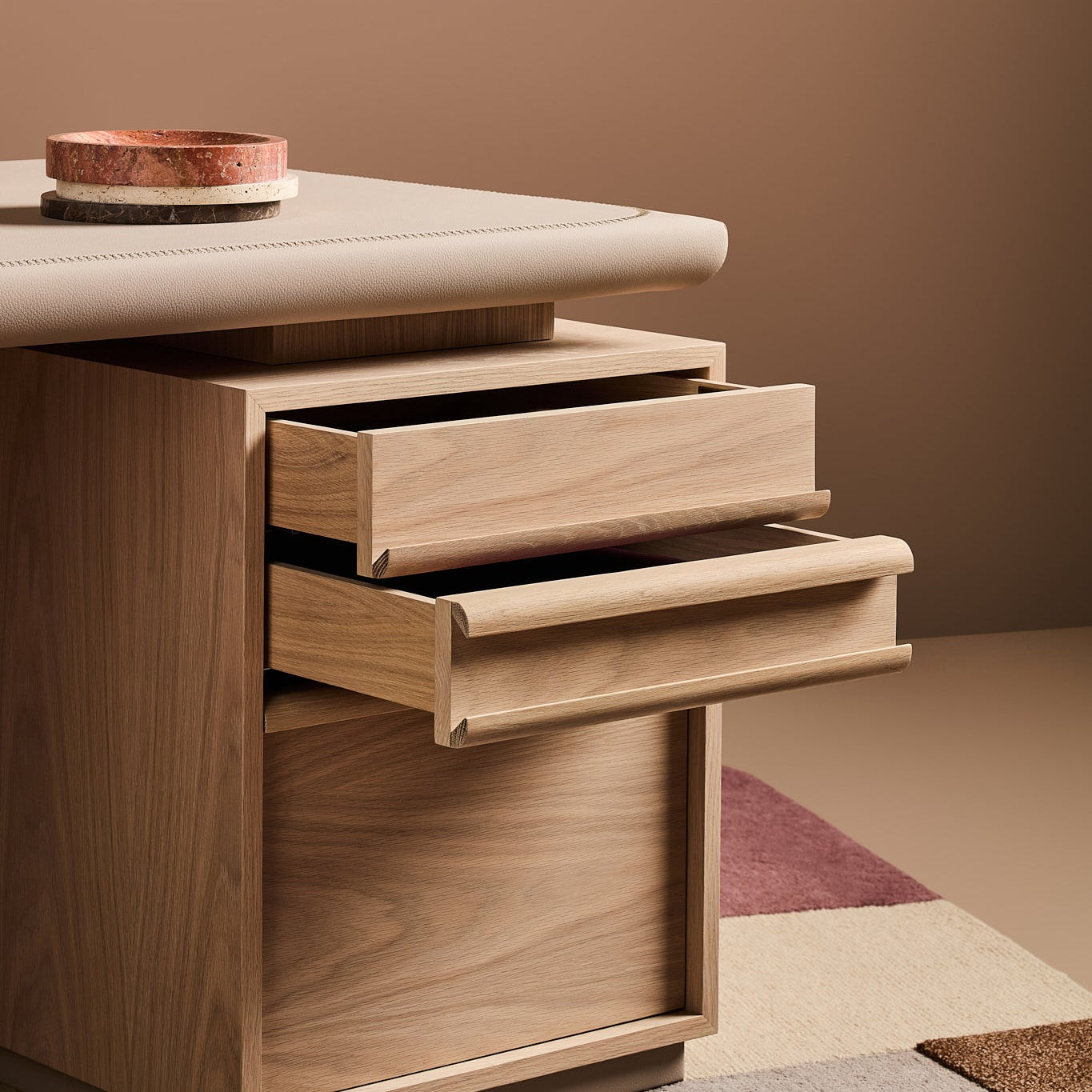 Wooden drawer unit with two open drawers on a neutral background
