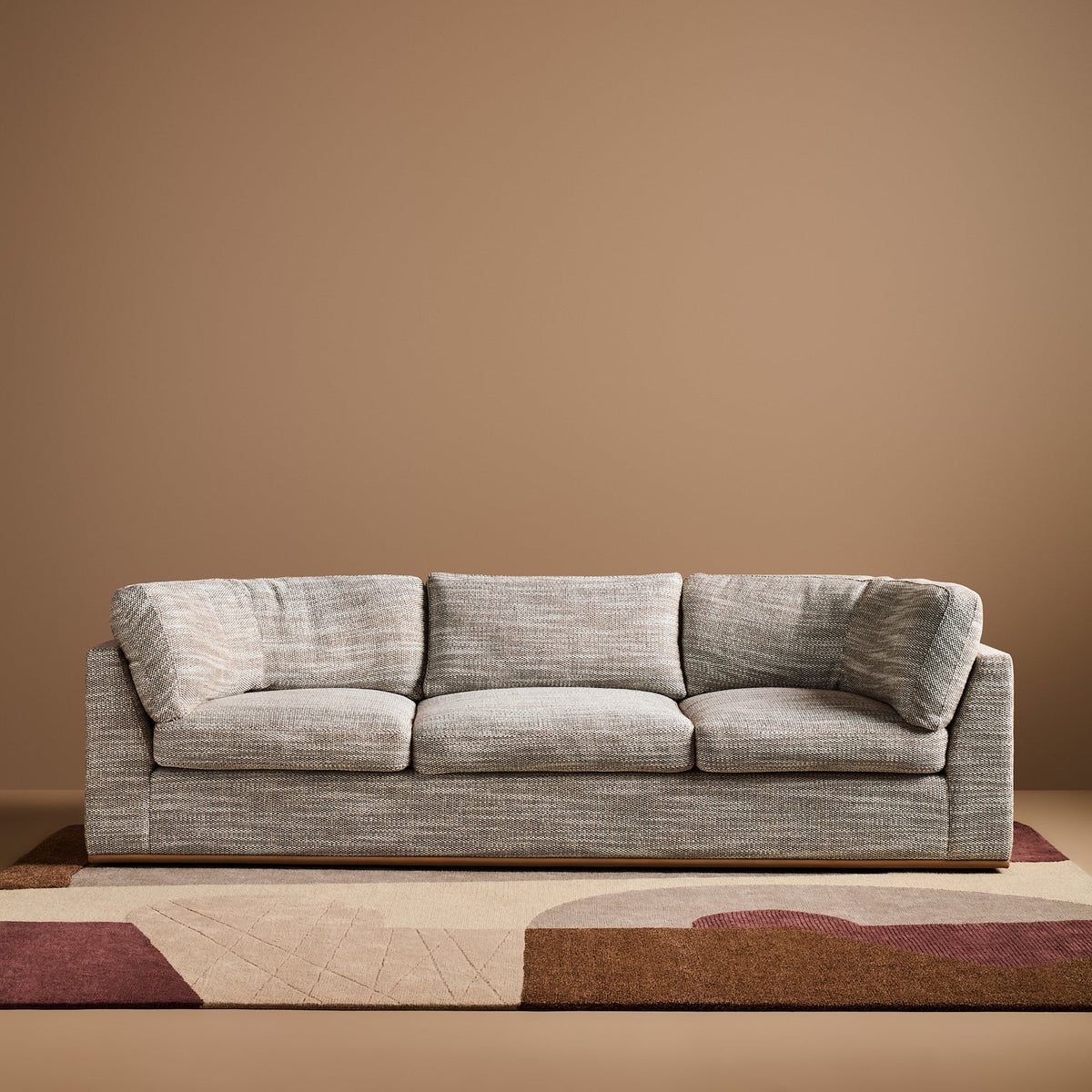Sabrina Curved Sofa on leather plinth in Matrix Woven Dream with Tan Leather plinth